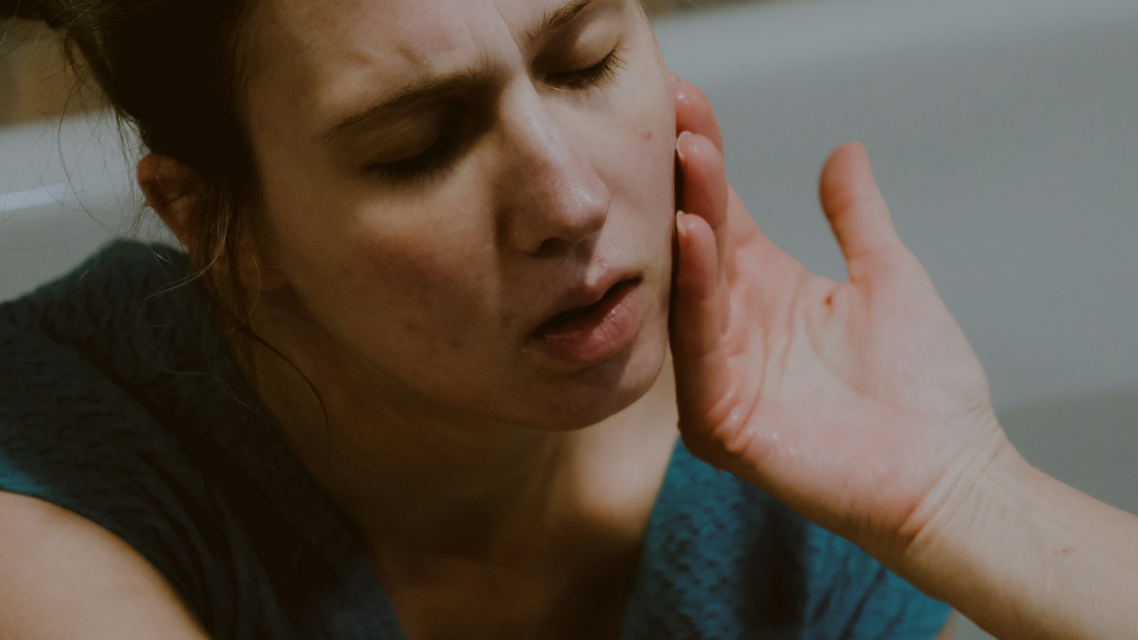Woman holding her jaw in discomfort