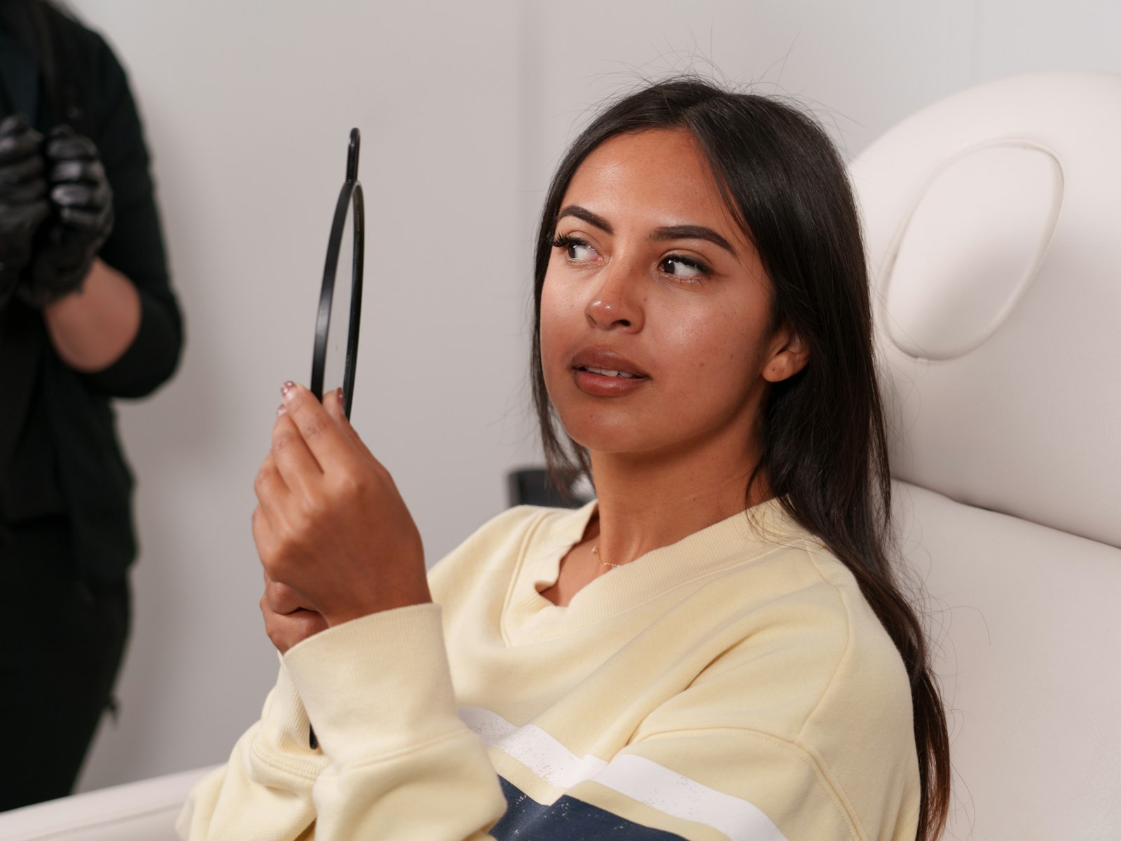 Doctor examining a woman's face during an aesthetic consultation